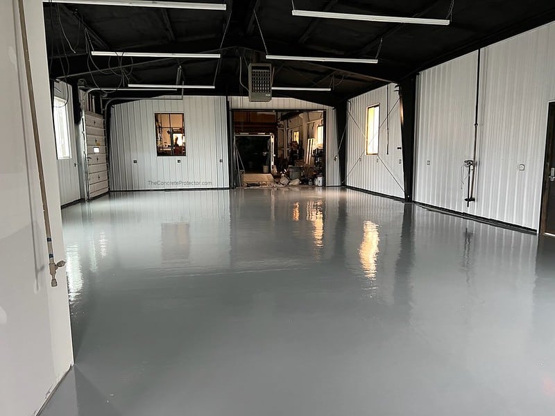 Industrial Polyurethane Coatings | 123 Resinous Epoxy Industrial Flooring with a smooth and glossy surface in shades of gray. The flooring is highly durable and ideal for commercial and industrial settings, with a slightly reflective quality that adds depth and texture to the space.